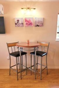 a table and two chairs with paintings on the wall at Comfy studio in Sarasota in Sarasota +4 photos