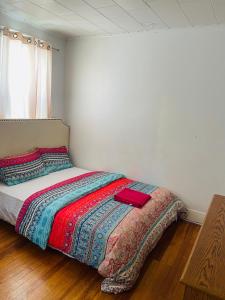 a bedroom with a bed with a red blanket at Muna’s Place in Newark