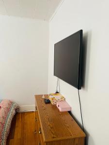 a flat screen tv sitting on a wooden table in a room at Muna’s Place in Newark