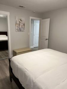 a bedroom with a white bed and a mirror at Downtown Deluxe in Sacramento