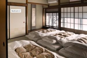 a room with four beds in a room with windows at moku杢 in Miyazu