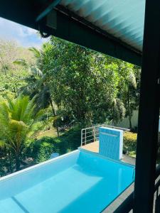 a view of a swimming pool from the window of a house at White House Holiday Resort in Ratnapura