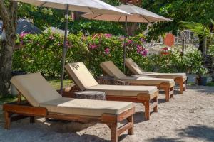 a row of lounge chairs and an umbrella at Marika Resort in Badian