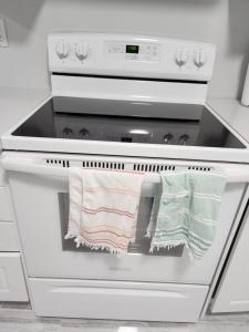 a stove with two towels hanging on the oven at SUITE A 2 Bedroom Apartment in Brampton