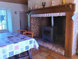 Cette chambre dispose d'une cheminée, d'une table et d'une cuisinière. dans l'établissement Gîte Les Coteaux Périgourdins, 3 pièces, 4 personnes - FR-1-616-291, à Grèzes