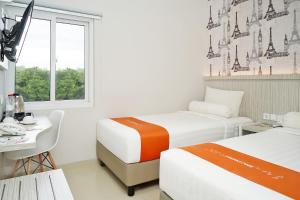 Rúm í herbergi á Front One Hotel Sragen