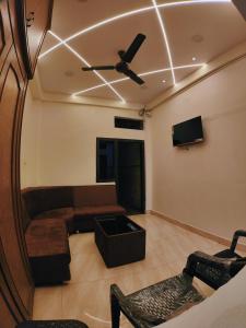 a living room with a couch and a ceiling fan at Shivalay Premium Homestay in Ujjain