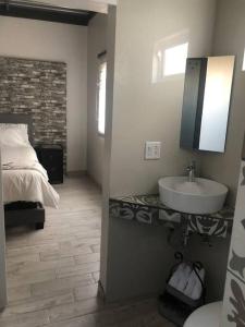 a bathroom with a bed and a sink in a room at Terraza parque revolución in Ensenada