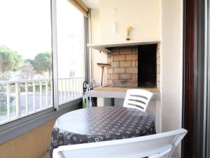 a table and chairs on a balcony with a fireplace at Appartement T2 avec clim, parking et wifi - Balaruc-les-Bains - FR-1-553-241 in Balaruc-les-Bains