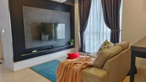 sala de estar con silla y TV de pantalla plana en A3. The Sun @ Revo Aurora Pavillion, en Kuala Lumpur