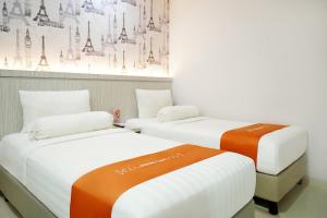 Rúm í herbergi á Front One Hotel Sragen