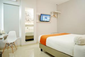 Rúm í herbergi á Front One Hotel Sragen