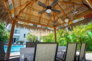 a patio with a ceiling fan and chairs and a pool at Departamento Mauricio #2 in Bucerías