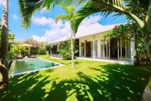 ein Haus mit einem Garten mit einem Swimmingpool in der Unterkunft Vicolo ArtVillas in Uluwatu