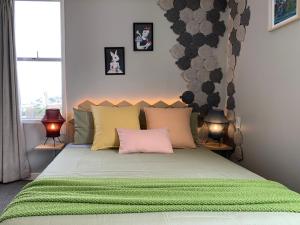 a bedroom with a green bed with two lamps at Central Nest- view & style in Wellington