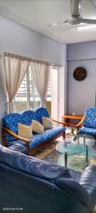 een woonkamer met een blauwe bank en een glazen tafel bij A room in Aparnt Sri Impian in Johor Bahru