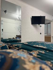 una camera da letto con due letti e una TV a parete di 1-комнатная квартира a Ekibastuz