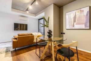 ein Wohnzimmer mit einem Glastisch und einem Sofa in der Unterkunft Urban Hideaway in Melbourne's Epicentre in Melbourne