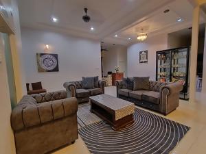 a living room with couches and a coffee table at Awang's Villa Homestay in Kampong Gong Badak