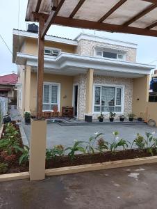 una casa con patio frente a ella en Azizah's Syariah Homestay, en Padangluar