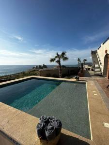 a swimming pool with roses in a basket next to the ocean at Villa Tres Vistas. in El Pescadero