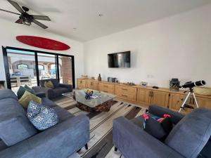 a living room with two couches and a table at Villa Tres Vistas. in El Pescadero