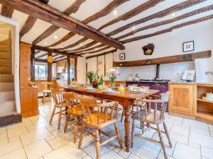 a large kitchen with a wooden table and chairs at Sycamore Farmhouse in Ipswich