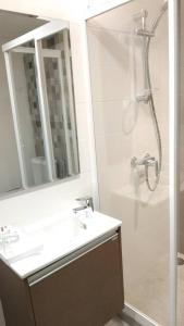 ein Bad mit einer Dusche, einem Waschbecken und einem Spiegel in der Unterkunft Prom Hotel in Bangkok