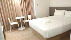 1 dormitorio con 1 cama, mesa y sillas en Prom Hotel en Bangkok