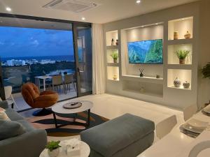 CupecoyにあるGorgeous 2 bedroom, 17th floor, with breathtaking view, Fourteen at Mullet Bayのリビングルーム(ソファ、テーブル付)