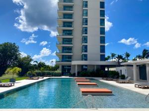 a swimming pool in front of a tall building at Gorgeous 2 bedroom, 17th floor, with breathtaking view, Fourteen at Mullet Bay in Cupecoy