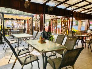 un restaurant vide avec des tables et des chaises dans un bâtiment dans l'établissement Emma, à Ban Pak Khlong Phe