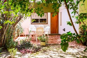 un patio con sillas blancas y una puerta de madera en Casa Grande con estacionamiento en San Juan