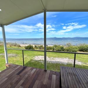 a view of the beach from the porch of a house at Wilsons Prom Holiday Park in Yanakie