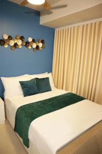 a bedroom with a large bed with a blue wall at Homefort iHotel at S Residences in Manila