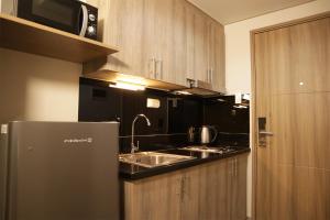 a kitchen with a sink and a refrigerator at Homefort iHotel at S Residences in Manila