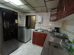 una pequeña cocina con fregadero y nevera. en HospedajesMED, en Medellín