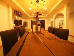 a large wooden table in a room with chairs at Rock Garden Beach D19 Pool Villa in Rayong