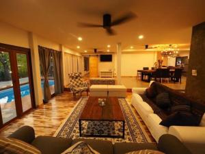 a living room with couches and a dining room at Rock Garden Beach D19 Pool Villa in Rayong
