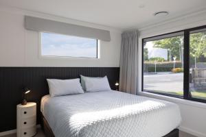1 dormitorio con cama blanca y ventana en The Corner on Te Mata en Havelock North