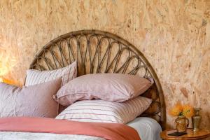 cabecero de madera con almohadas encima de la cama en Dune Shack - Waterfront Retreat en White Beach