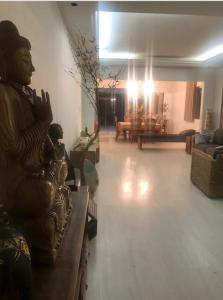 a living room with a statue of a man sitting on a couch at Casaclassea in Juiz de Fora