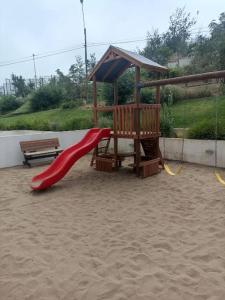 a playground with a red slide and a bench at Departamento Alto de Placeres Valparaiso in Viña del Mar