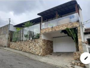 a house with a stone wall and a garage at Casaclassea in Juiz de Fora