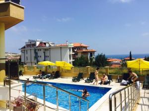 un groupe de personnes assises autour d'une piscine dans l'établissement Villa Galina Complex, à Byala