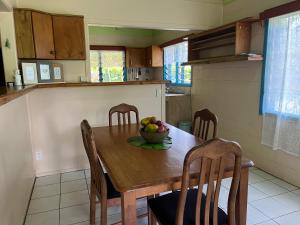 Sharnyta’s Guesthouse في أفاروا: مطبخ مع طاولة خشبية مع وعاء من الفواكه عليه