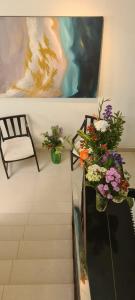 a staircase with two vases of flowers and a painting at Lotus Colombo Guesthouse in Colombo