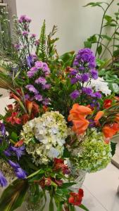 eine Glasvase gefüllt mit bunten Blumen auf einem Tisch in der Unterkunft Lotus Colombo Guesthouse in Colombo