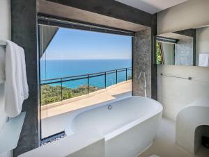 eine weiße Badewanne im Bad mit einem großen Fenster in der Unterkunft Moonshadow - Multiple Award Winning Villa in Chaweng Noi in Strand Chaweng Noi