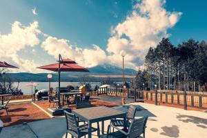 een patio met tafels en stoelen en uitzicht op een berg bij Fuji Yamanakako Resort Hotel - Vacation STAY 03089v in Yamanakako